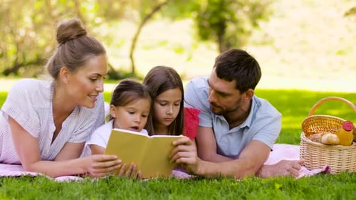 Happy Family Reading Book on Picnic Blanket