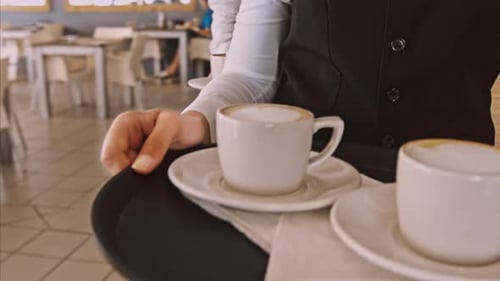 Mittleres Steadicam-Video von Kellner und Kaffee auf einem Tablett im Gehen