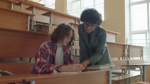 Student Working with Teacher in Lecture Hall