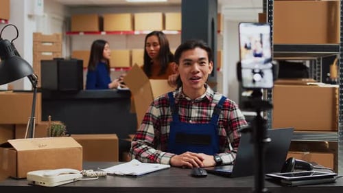 Male Employee Filming Promotion Video in Warehouse
