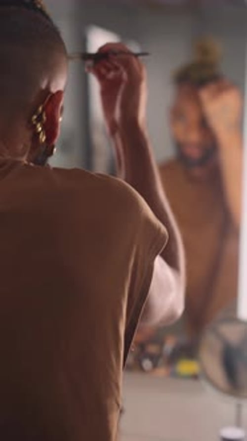 Young Adult Applying Makeup in Mirror