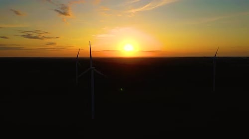 Wind Turbines Silhouetted Against Vivid Sunset Sky