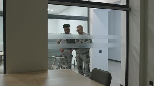 Two Men Working on Laptop in Office