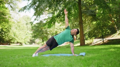 Asian Japanese Man Exercising at Park Making Yoga Exercise Stretching Sports Training on Mat