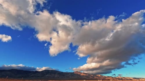 Huge cloudscape rolling over the Mojave Desert with cars traveling along the highway at the base of