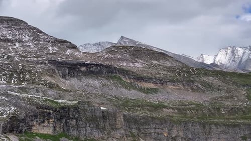daytime mountain landscape dynamic slow stable drone shot in alpine environment and moody cloudy sky