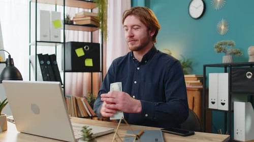 Homem de negócios rico feliz contando dinheiro, dividendos em dinheiro, dividendos, salário e usando laptop no escritório doméstico