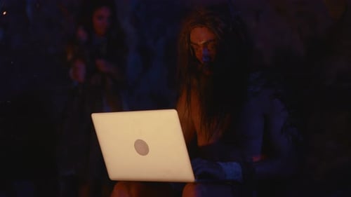 A Caveman in a Modern World Skillfully Using a Laptop and Engaging with Technology
