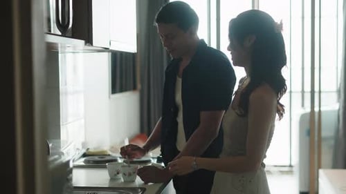 Young Couple Prepares Drinks in Kitchen
