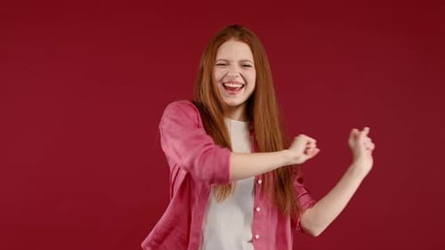 Energetic Woman Dancing Happily on Red Background