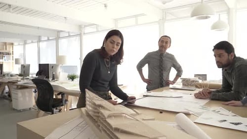 Architects collaborating on building design model in bright canadian studio