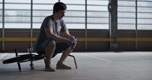 Young Adult Resting on BMX Bike Indoors