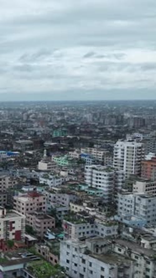 Dense city buildings under cloudy skies aerial view