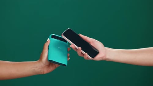 Card machine, phone and hands of people in studio for payment, transaction or contactless POS