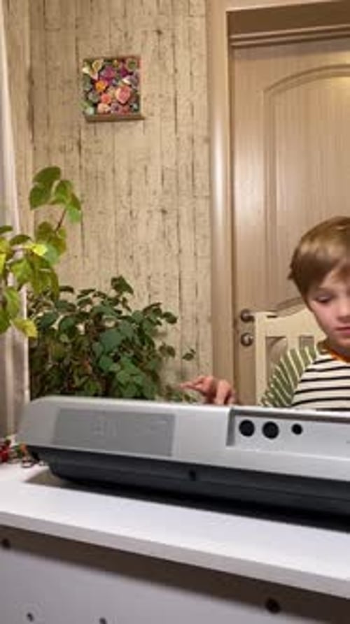 Boy Learning Piano with Adult Guidance