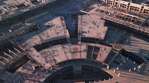 Complejo de construcción circular de concreto aéreo con drones al atardecer de Golden Hour