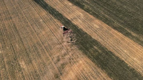 Tractor Plowing Field After Harvest in Autumn