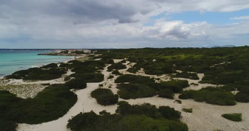 Aerial Drone Shot of a Beach with white Sand and a lot of Bushes, cloudy Day, Mallorca, Spain, 4k