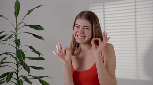 Smiling Woman Gives Okay and Thumbs Up