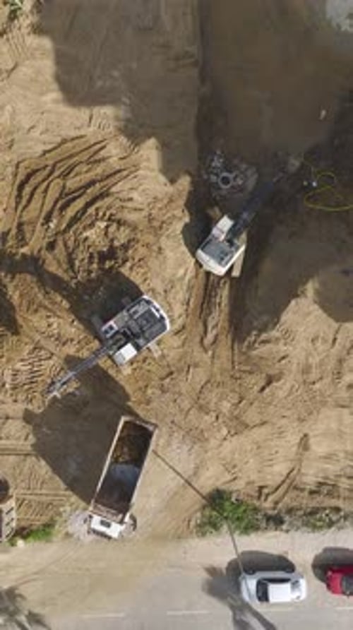 Vertikales Video: Die Konstruktion eines neuen Projekts wurde mit Bauarbeitern und schwerem Gerät aufgenommen