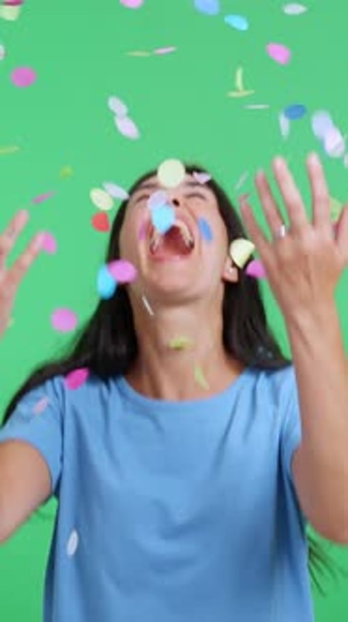 Excited Woman Celebrates as Colorful Confetti Falls on Her