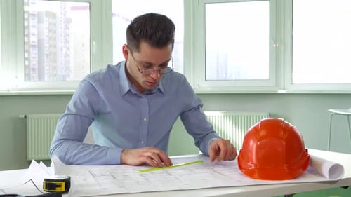 Architect Draws Building Plan at Desk