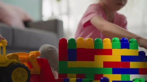 Linda chica toma bloques de plástico de colores para construir una estructura