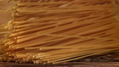 Spaghetti Falling onto a Rustic Wooden Surface
