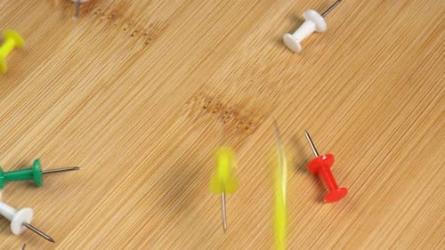 Colorful push pins falling down on the table. Drawing pins for marking on the map of the Earth
