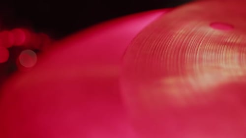 Metal Cymbal Hit by Drumstick in Red Lighting