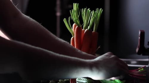 Person Bundling Fresh Carrots on a Table