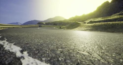 Estrada sinuosa panorâmica através da paisagem montanhosa ao pôr do sol