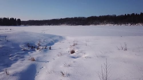 Paysage d'hiver ensoleillé d'un village de campagne et d'une rivière gelée 04