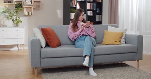 Woman Relaxing on Couch Using Cell Phone