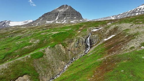 River Flows Through Mountains in Summer Season Waterfalls on Hills in Iceland