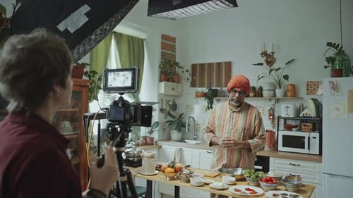 Man Explaining Food Preparation to Videographer in Kitchen