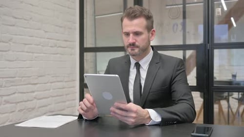 Corporate Man Using Tablet Device in Modern Office
