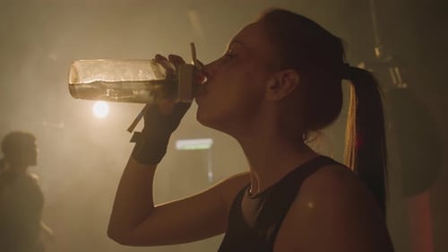 Athletic Woman Drinks Water After Intense Training