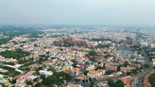 Malaikottai rock fort in middle of Tiruchirappalli city's dense urban buildings, aerial panoramic do