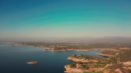Aerial drone flying over a lake, water dam, with mountains at sunrise. Beautifull dreamy landscape