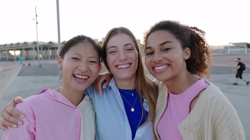 Three Smiling Friends Embrace on City Street
