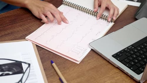 Cardiologist ECG Analysis Examines Patient Cardiogram ECG Test Results at Table with a Computer