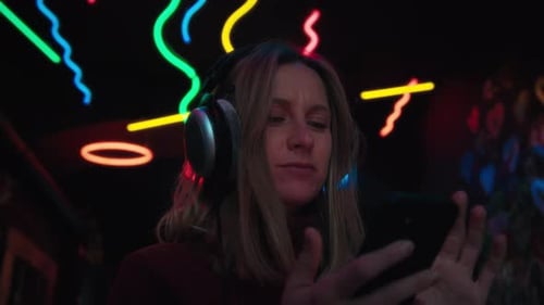 Woman with Headphones Listening to Music at Night