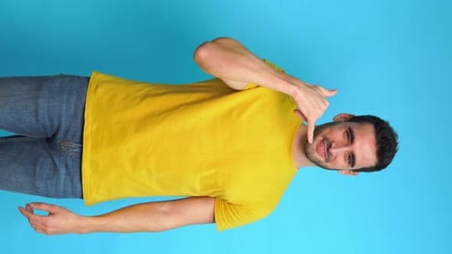 Cheerful Man Doing a Call Me Gesture Looking at Camera