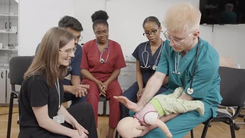 Medical Professionals Learning Infant CPR in Training Session