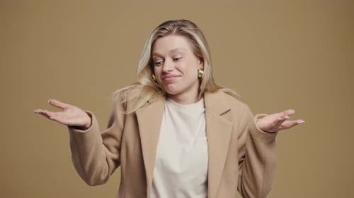 Attractive Woman Shrugs Shoulders with Uncertain Expression