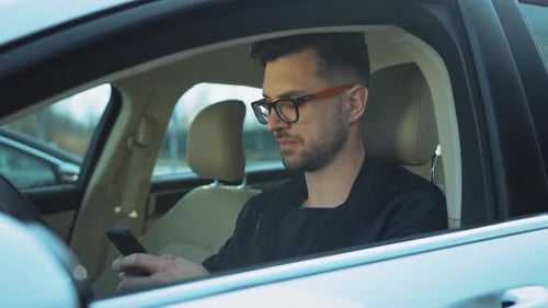 Young Adult Using Smartphone in Car