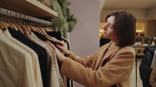 Caucasian Woman Shopping In Mall Visiting Clothing Store And Choosing New Dress Medium Portrait