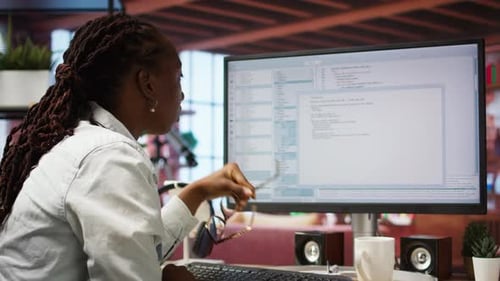 Woman Working on Computer Coding in Office