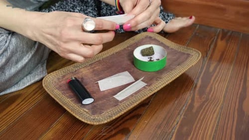 LGBT Woman Preparing a Cannabis Joint